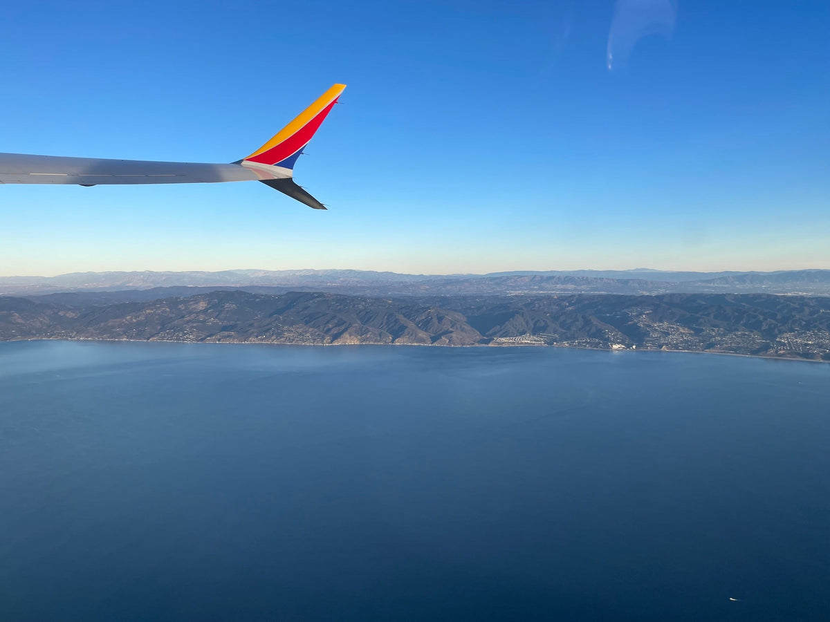A view from an airplane window, representing the low-humidity conditions that dry out skin during flights